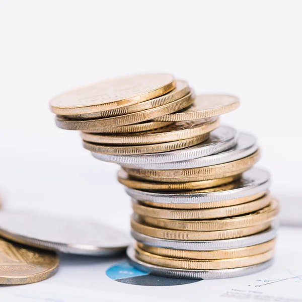 A stack of coins neatly arranged on a table, with a Gutter Guard product visible in the background.