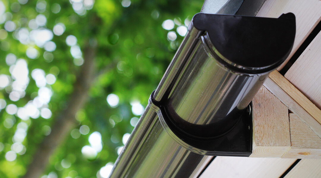 Vue extérieure d'une maison moderne avec des gouttières en aluminium installées le long du toit.